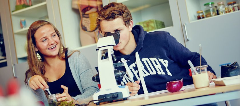 Elever ser i mikroskop i realfag - Klikk for stort bilde